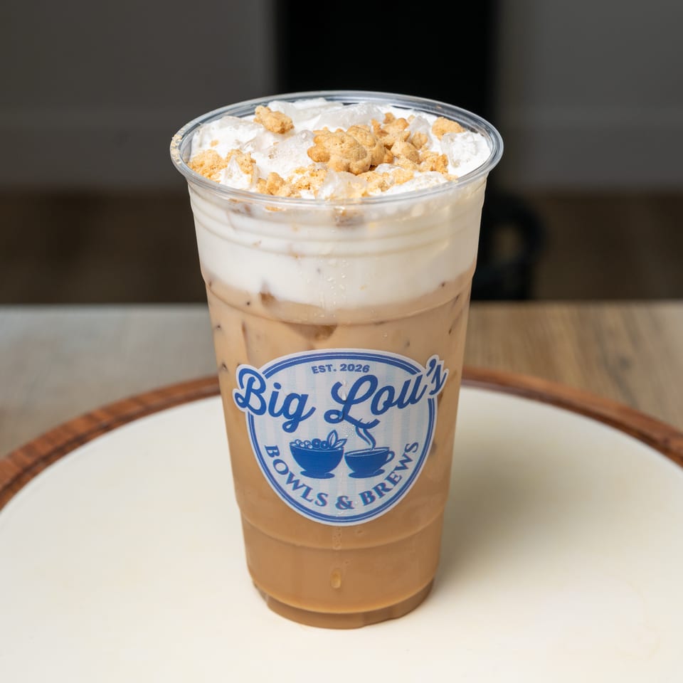 Iced coffee topped with whipped cream and cookie crumbles in a Big Lolli’s Bowls & Brews cup.