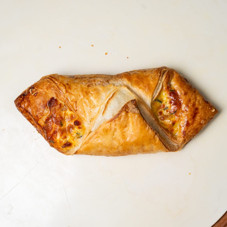 Golden-brown cheese-filled pastries arranged on a white plate.